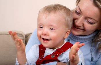 Mom with a smiling baby with Down syndrome