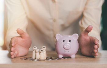 men show protection and safety protection to wooden dolls and piggy banks the concept of insurance